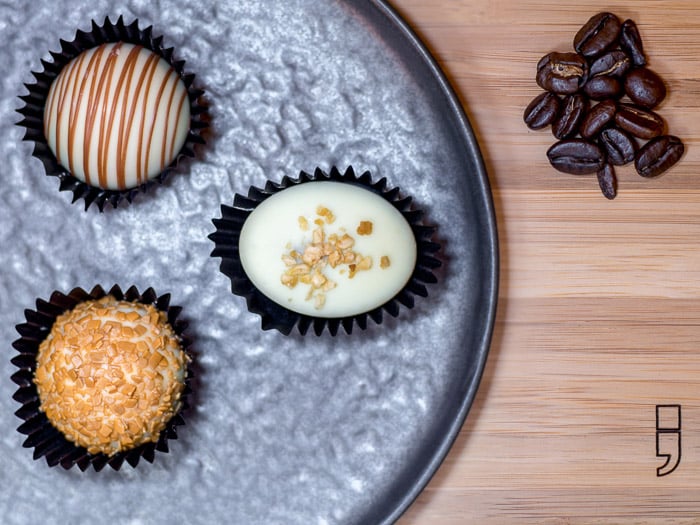 A focus stacked bird's-eye view of Belgian pralines on a metal plate