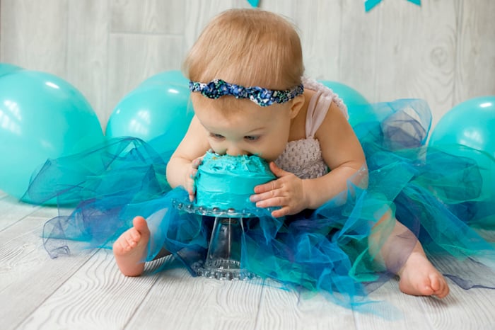 Cute diy cake smash photo shoot of a baby eating a green cake