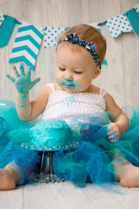 Cute diy cake smash photo shoot of a young baby smashing a green cake 