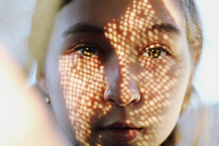  Self-portrait photography close up of a woman's face covered by a shadowy pattern