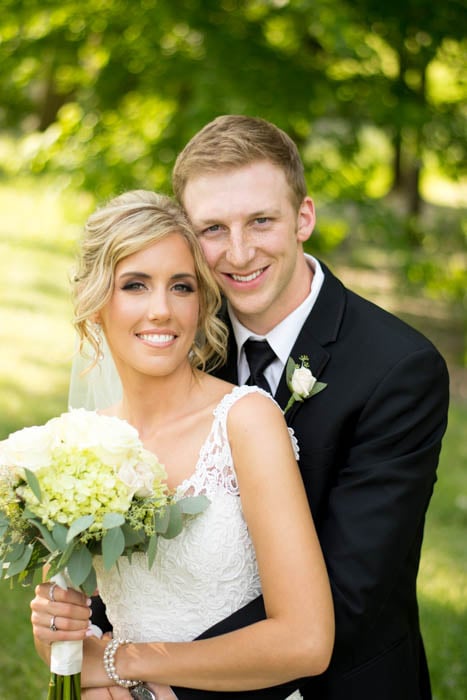 A wedding portrait of bride and groom with bouquet