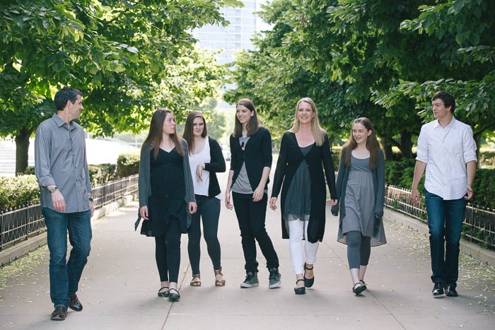 lifestyle photo of a large family (parents with 5 teenage children) walking casually through the park towards the camera