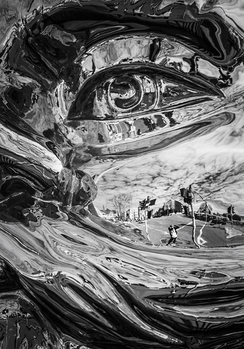 Black and white photo with photographer's reflection in 'Reflective Lullaby (John)' sculpture by Gregor Kregar. Creative street photography