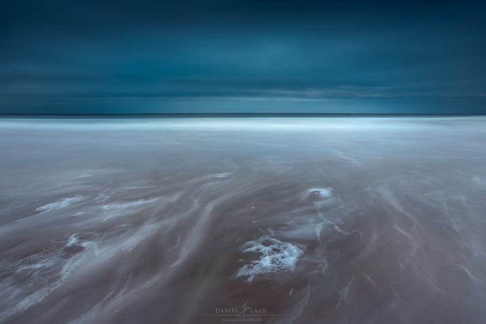 An dramatic fine art landscape photography shot of the seashore leading to a stormy sky.