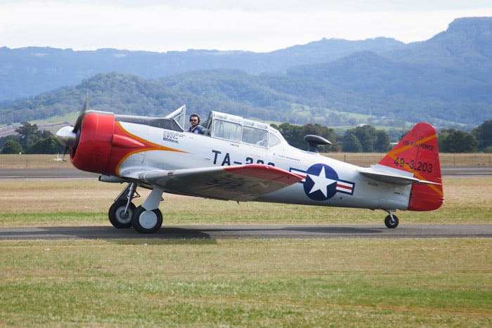 An airshow photography shot of a red and white airplane taxiing on the runway