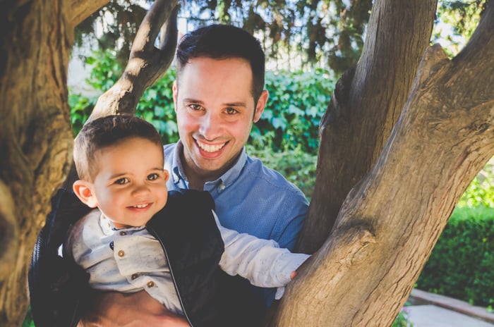 Sweet family portrait of a father and son posing by trees