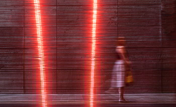 A color street photography shot of a woman walking past artwork 'Aeriology' by David Haines and Joyce Hinterding. black and white vs color street photography.