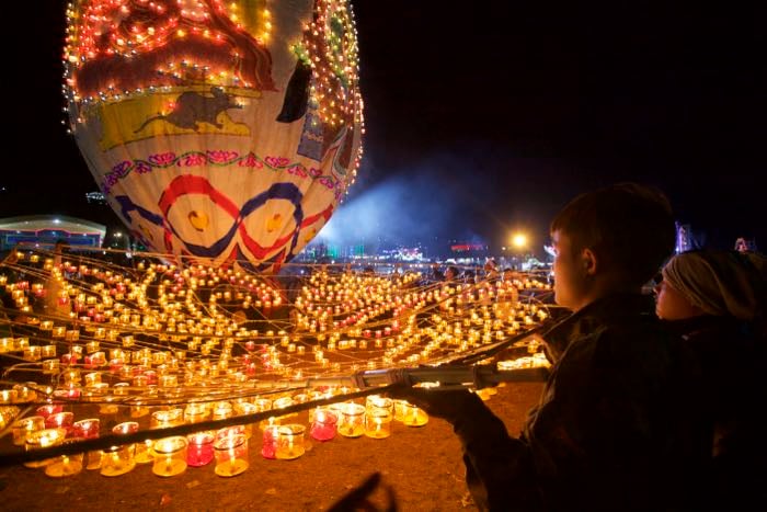 Night photography of people watching a light display - travel photography checklist.