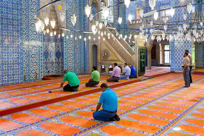 Photo of men worshiping in a temple. 