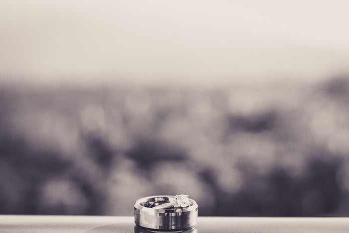 A black and white close up photo oof a wedding ring on a window sill.