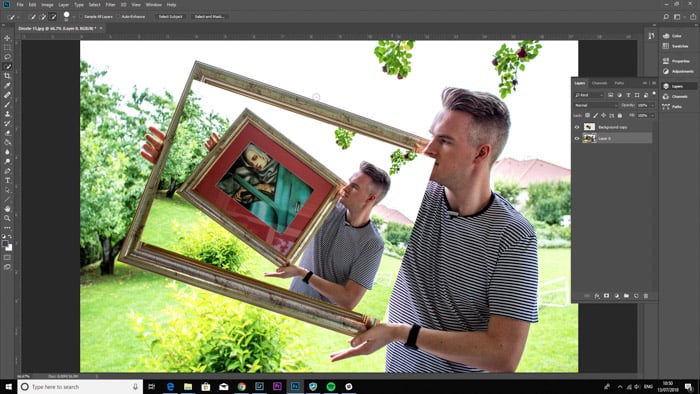 Screenshot of Photoshop editing a photo of a man holding a framed painting - droste-effect step four