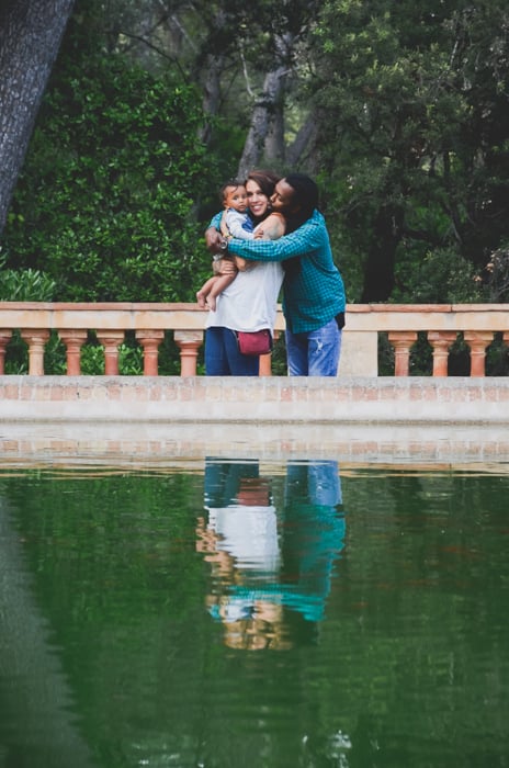 A couple with a small baby posing in front of a pond - composition for family picture ideas