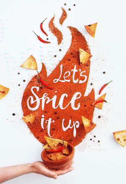 A hand holding a bowl of chips with the typography message 'lets spice it up' with nachos and spices