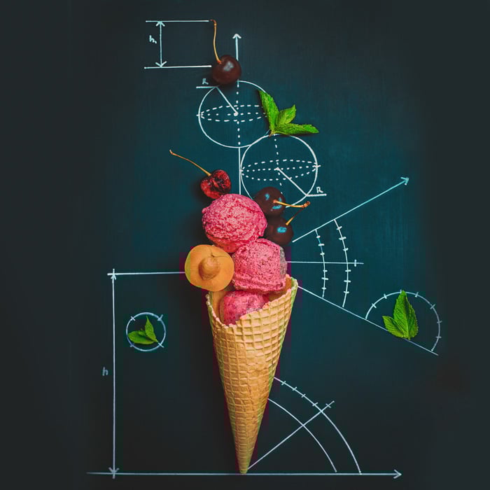 A creative still life flat lay idea with an ice-cream cone on a chalkboard surface