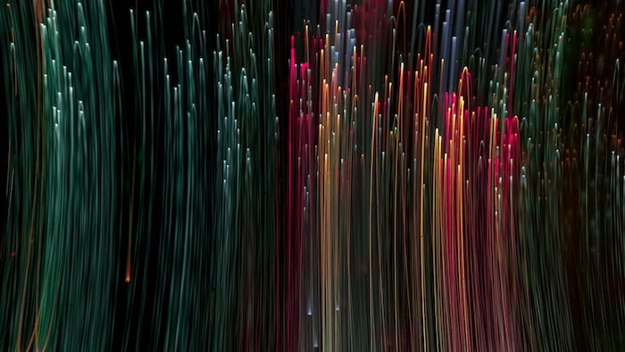 Colorful lines of vertical light against a dark, black background