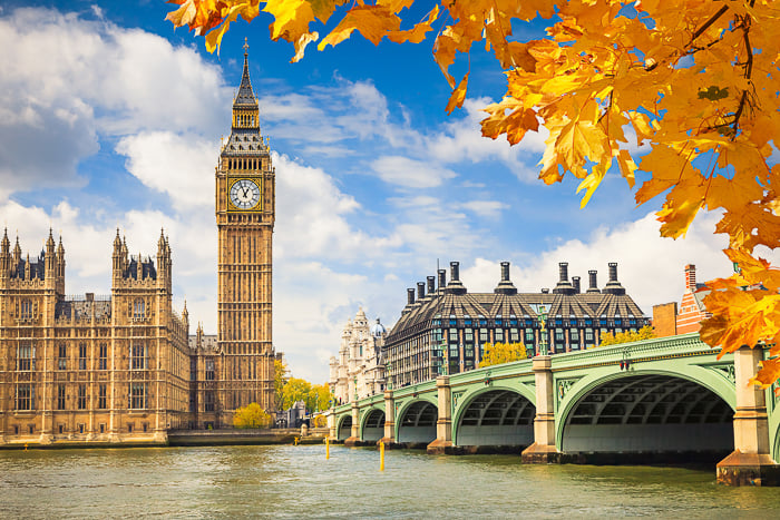 Big Ben clock tower and bridge against a blue sky on a bright autumn day