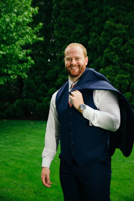 A wedding portrait of the groom posing outdoors
