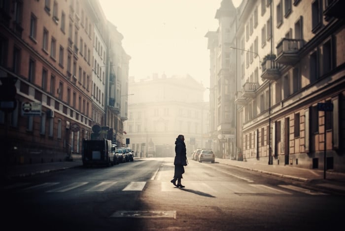 Atmospheric low light street photography shot of a person crossing the road
