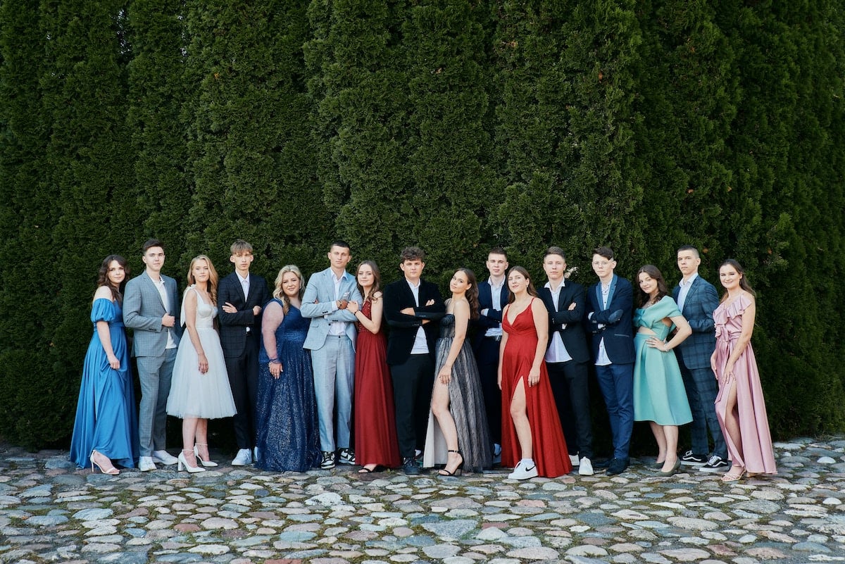 Large group photo of dressed-up high-shchool graduates outside