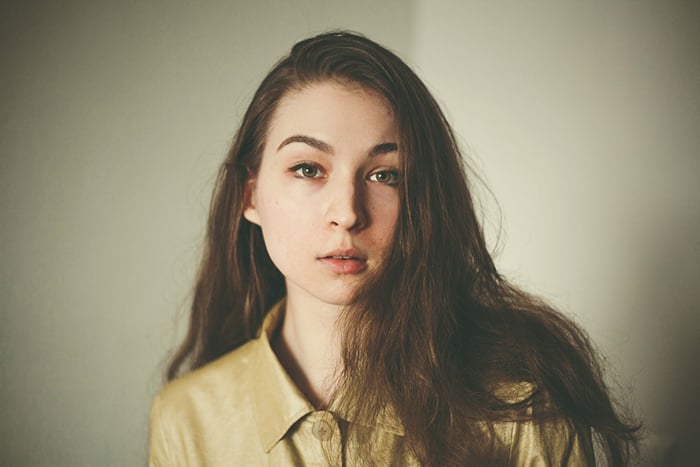 A cool profile photo of a girl posing against a soft background