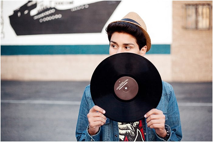 A cool senior portrait of a young man posing with a vinyl record