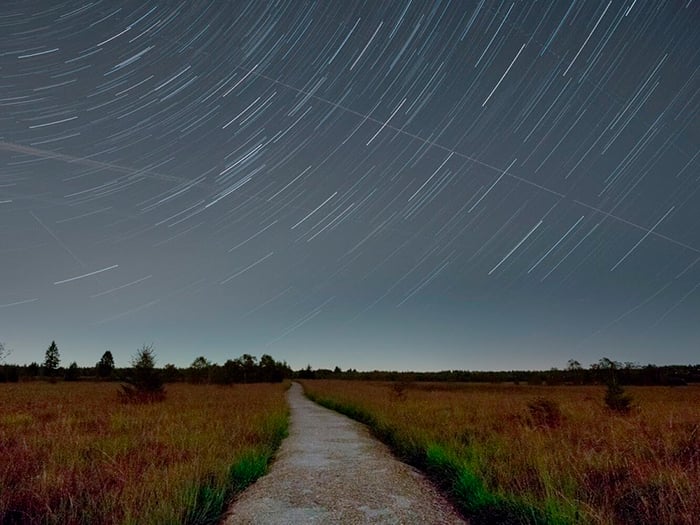 Summer star trails over a quiet countryside road