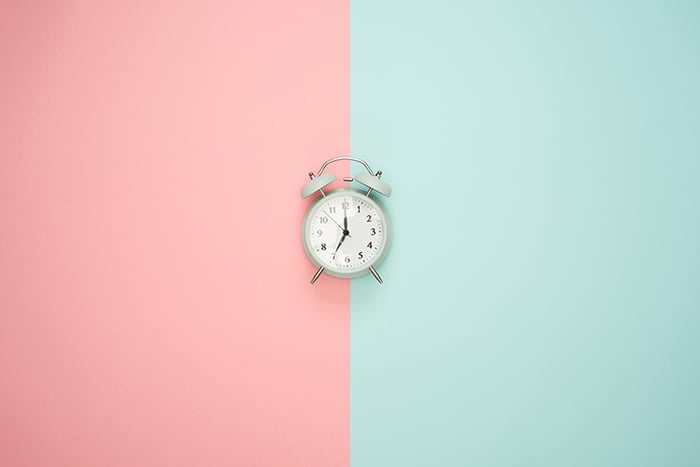 A quirky product shot of an alarm clock demonstrating symmetry in photography due to the central composition and split color background