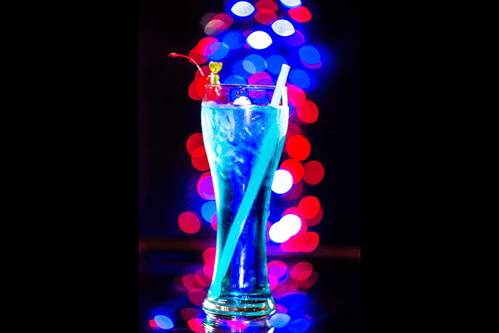 A blue cocktail with blurry bokeh light background