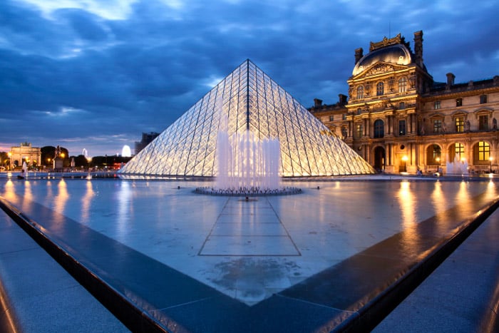 The exterior of the Louvre at night.