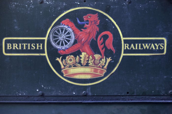 A British railways sign on the side of a steam train. 