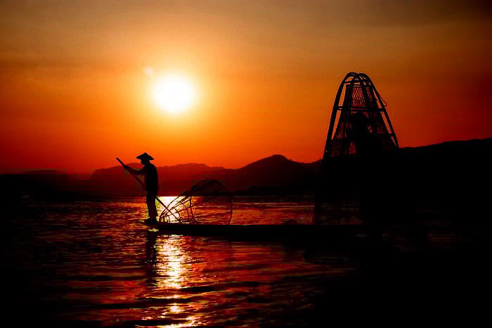 A portrait of fishermen on Inle Lake in Myanmar at sundown