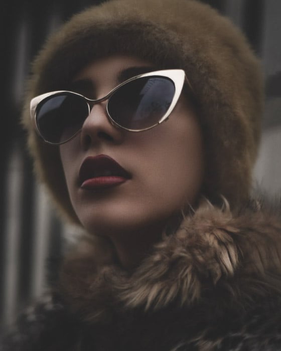 A beauty editorial fashion shot of a female model posing in sunglasses and fur - fashion photography types