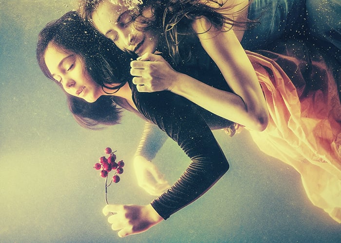 two women with closed eyes floating underwater as an idea for shooting fine art portrait photography