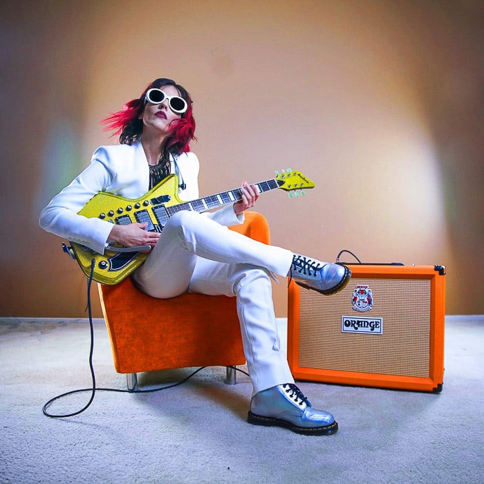 A portrait of a female musician playing an electric guitar shot with studio lights