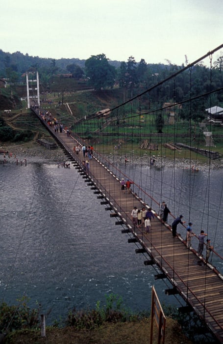 Aerial view of a group of people crossing a wooden bridge