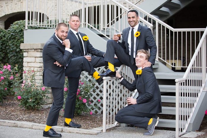 A fun casual wedding portrait of a group of groomsmen hanging out and enjoying themselves.