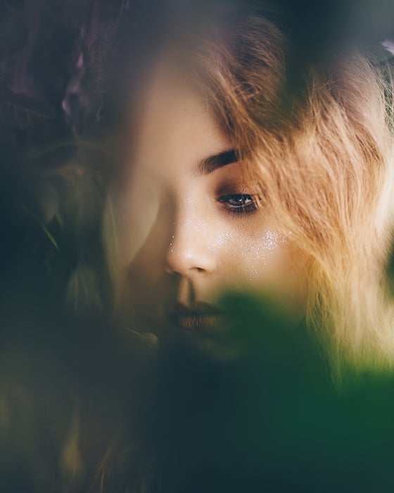Dreamy portrait of a blond female model surrounded by shadows and colored light - how to photograph the female face 
