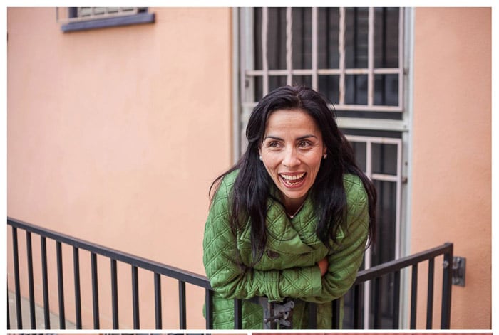 Casual headshot photo of a female model posing by a fence outdoors - headshot backgrounds ideas
