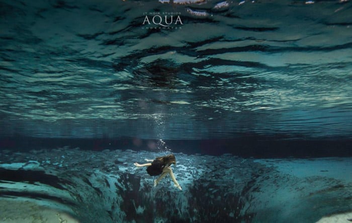 Dreamy underwater portrait of a female model swimming