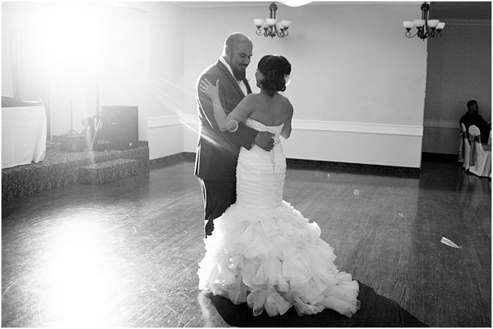 A monochrome wedding portrait of the couple dancing - wedding flash photography