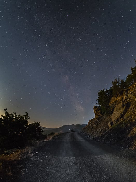 A country road at night under a star filled sky