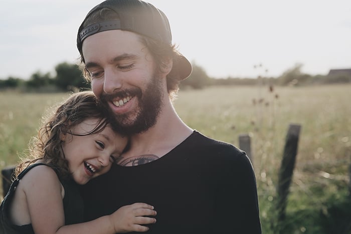 Sweet portrait of a smiling father and young daughter outdoors - how to smile for pictures