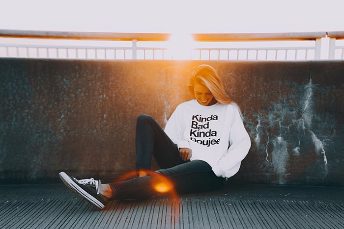 A female model sitting outdoors and smiling naturally - smile for the camera