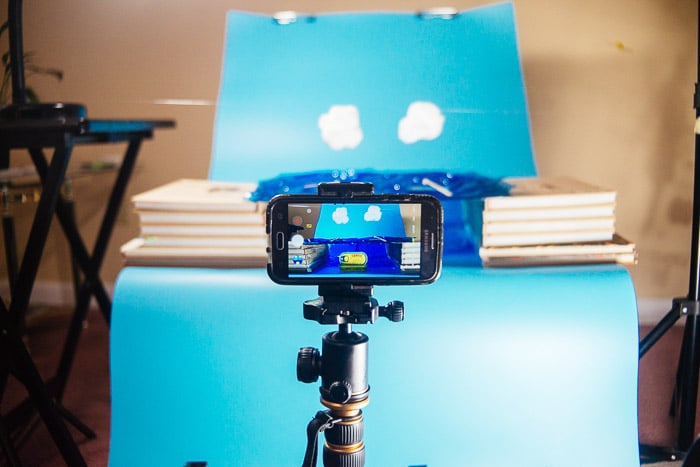 A phone set up on a tripod for someone to shoot smartphone product photography