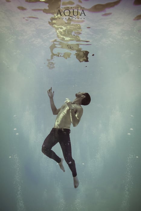 Atmospheric underwater photoshoot of a male model posing underwater