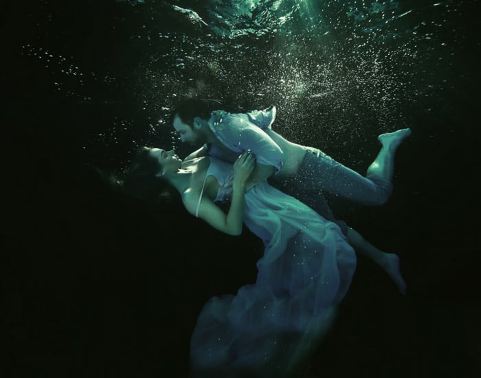 Atmospheric underwater photoshoot of a couple embracing underwater