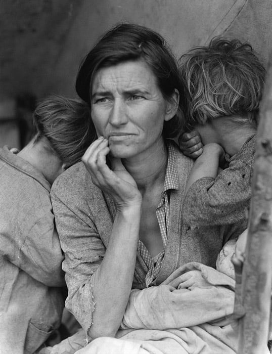 A woman in an outdoor setting, surrounded by two children.