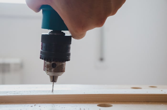 a person making a DIY wood backdrop for photography