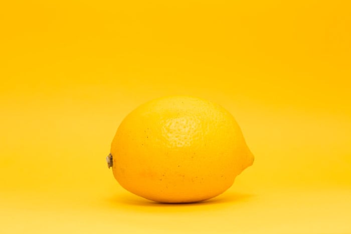 a lemon on yellow background - symbolism in photography