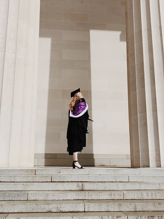 a graduate from a photography school standing outside the university 